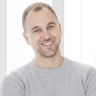 man with gray longsleeve top against a gray and white background